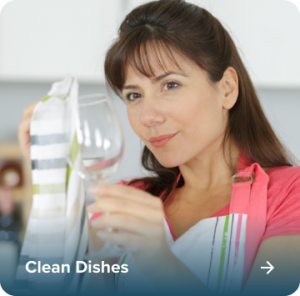 Woman admiring the sparkling clarity of dishes cleaned with soft water