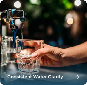 Crystal-clear water being poured into a glass, treated by Dooley’s Water Solutions