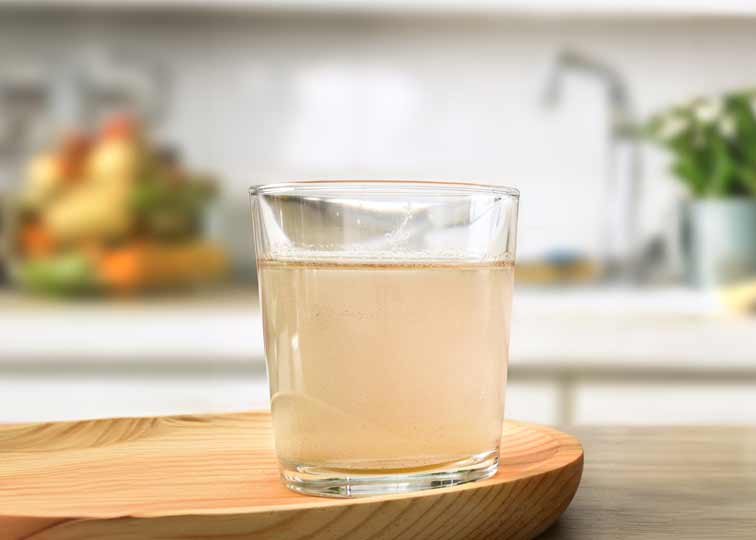 Glass of cloudy water on kitchen counter